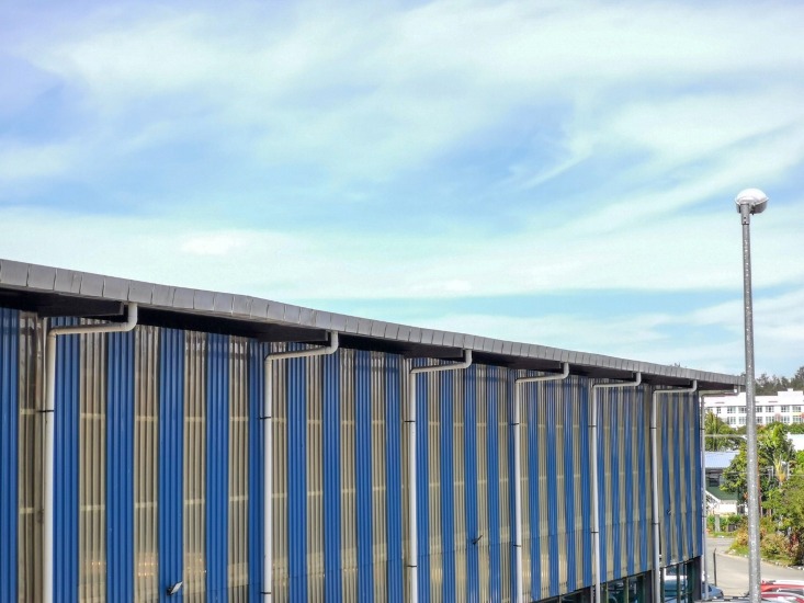 The blue color large gutter with water pipes in roof top