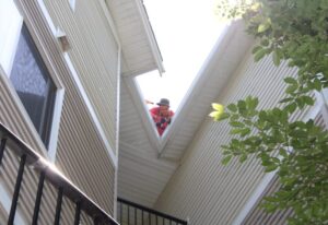 A gutter specialist installs new gutters on an apartment complex in Woodinville, WA