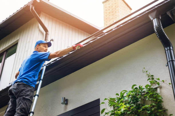 Gutter expert cleaning the gutters on a house in Seattle, WA