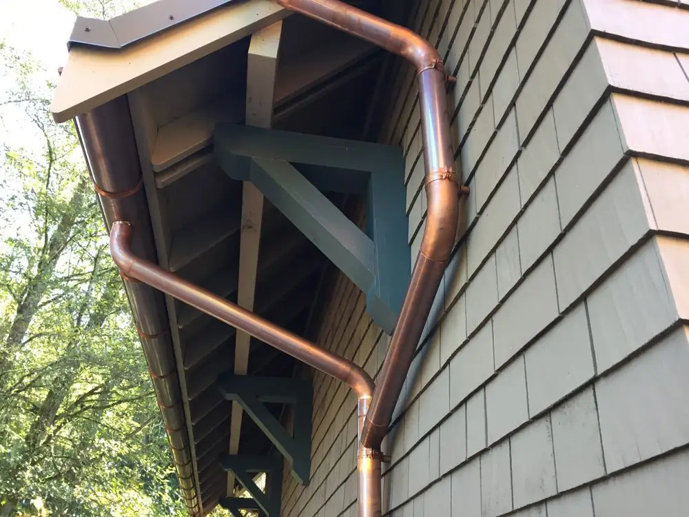 Copper half round gutter and round downspouts on a craftsman home in the Seattle area